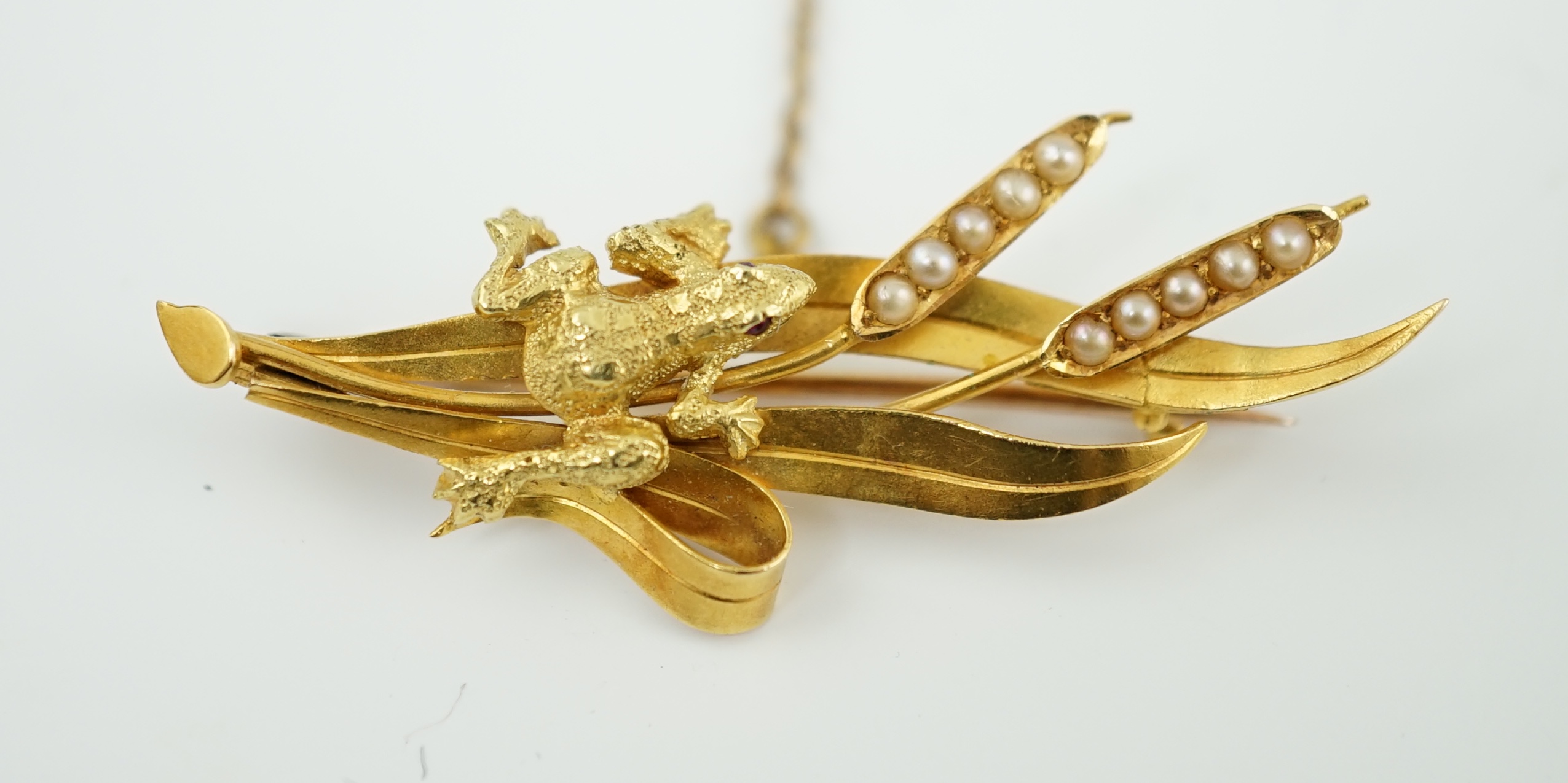 A late Victorian 15ct gold 'Regard' ring, modelled as two hands clutching a flower head, size K, together with a 15ct gold and seed pearl bar brooch, modelled as a frog upon bulrushes